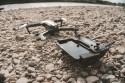Strzal z bliska zaawansowanego technicznie drona i jego zdalnego urzadzenia sterujacego na szarych kamykach