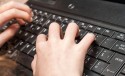Dłonie na klawiaturze laptopa