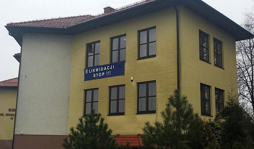 Budynek gimnazjum w Tomicach. Na szkole wisi transparent ZNP, które sprzeciwia się likwidacji tej szkoły