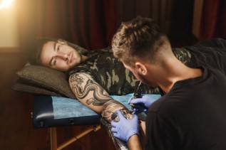 Mężczyzna podczas tatuowania nowego wzoru