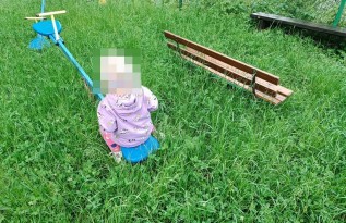 2-letnie dziecko bawi się w wyoskiej trawie
